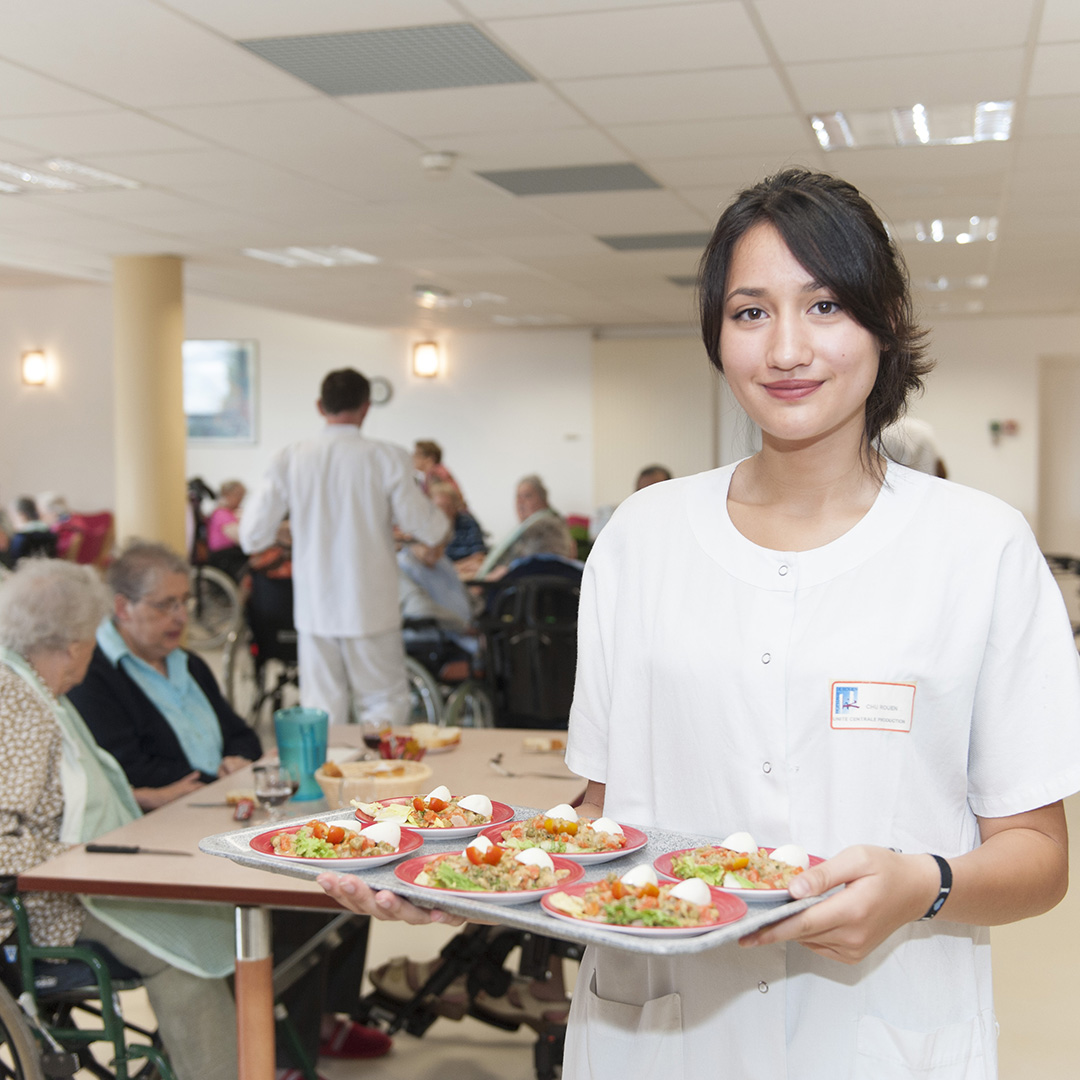 Une jeune femme réalise son job d'été en tant qu'gant du service de restauration du CHU de Rouen au sein d'un EHPAD/USLD